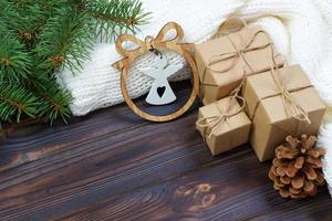 weihnachtsdekoration, geschenkboxen und engelsfigurenrahmenhintergrund, draufsicht mit kopierraum auf weißer holztischoberfläche. weihnachtsschmuck und präsentiert grenze foto