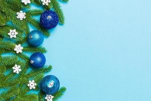 weihnachtskomposition aus tannenbaum, kugeln und verschiedenen dekorationen auf buntem hintergrund. Draufsicht auf das Adventskonzept des neuen Jahres mit leerem Raum für Ihr Design foto
