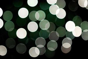 unfokussierter abstrakter bunter Bokeh schwarzer Hintergrund. defokussiert und verschwommen viele runde grünes Licht foto