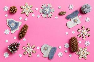 Draufsicht auf Weihnachtsspielzeug und Dekorationen auf rosafarbenem Weihnachtshintergrund. neujahrszeitkonzept mit kopierraum foto