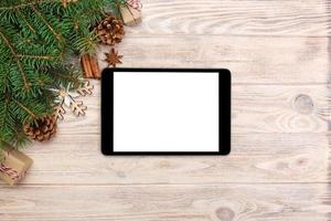 digitales tablet-modell mit rustikalen weihnachtsholzhintergrunddekorationen für app-präsentation. draufsicht mit kopierraum foto