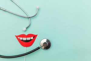 Gesundheitszahnpflegekonzept. Medizingeräte Stethoskop oder Phonendoskop Zeichen von Lächelnzähnen isoliert auf trendigem pastellblauem Hintergrund foto