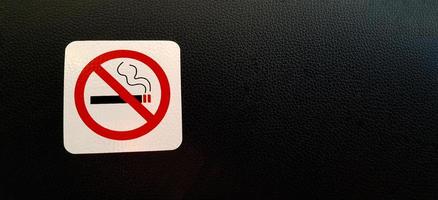 Rauchen Sie kein Zeichen oder Symbol auf schwarzem Lederhintergrund oder Tapete mit Kopierraum. strenger Ort oder Bereich erlaubt das Rauchen nicht. Regelkonzept foto