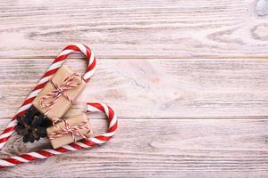 Zuckerstangen und Weihnachtsgeschenk auf braunem hölzernem rustikalem Weinlesehintergrund foto