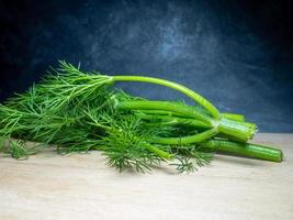 ein Bund Dill auf einem Schneidebrett. nützliches Produkt. Gemüse auf dem Küchentisch. vegetarische zutat für das mittagessen. foto