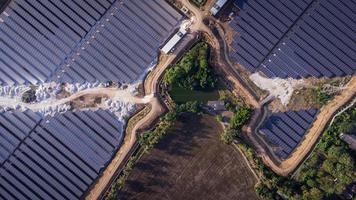 Luftaufnahme eines Solarparks, der abends saubere Energie produziert. rundum sichtbar foto