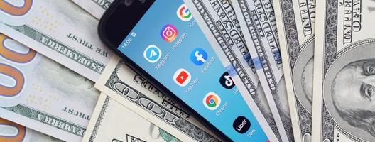 charkow, ukraine - 12. mai 2022 smartphone-bildschirm mit vielen beliebten apps und vielen hundert-dollar-scheinen. Business- und Social-Networking-Konzept foto