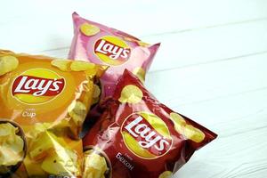 charkow, ukraine - 12. mai 2022 verschiedene geschmacksrichtungen von laienkartoffelchips auf holzhintergrund. Lay's war 1965 über Frito-Lay im Besitz von Pepsico foto