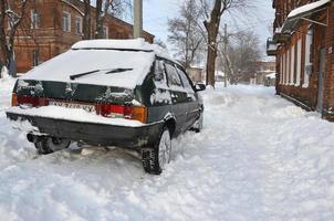 charkow, ukraine - 4. januar 2022 ein geparktes auto unter einer dicken schneeschicht. folgen eines starken und unerwarteten schneefalls in der ukraine foto