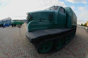 Foto eines russischen grünen Panzerwagens auf einer Gleiskette zwischen den Eisenbahnzügen. starke Verzerrung durch das Fisheye-Objektiv