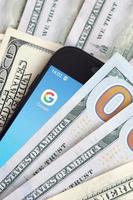 charkow, ukraine - 12. mai 2022 smartphone-bildschirm mit google app und vielen hundert-dollar-scheinen. Business- und Social-Networking-Konzept foto