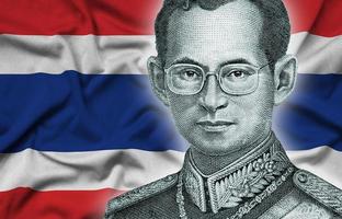 porträt von könig bhumibol adulyadej von 50 baht thailand geldschein in der nähe auf thailand-flaggenhintergrund foto