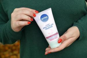 charkow, ukraine - 3. mai 2022 junges mädchen hält nivea sanftes creme-gel zum abwaschen. Nivea ist eine deutsche Körperpflegemarke, die sich auf Körperpflege spezialisiert hat foto