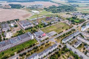 Luftpanorama aus großer Höhe einer kleinen Provinzstadt mit privatem Sektor und Wohnhochhäusern foto