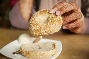 Frauen, die ein frisches Bagelbrot halten foto