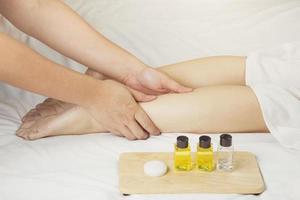 Die Hand des Massagetherapeuten massiert die Wadenmuskeln der jungen Frau im Spa-Salon. Gesundheitskonzept, Entspannung oder die Pflege der Beinhaut mit Naturprodukten