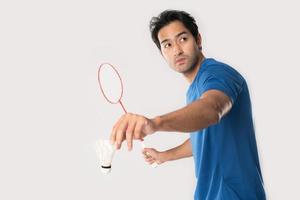 ein Badmintonspieler in Sportbekleidung steht mit Schläger und Federball. foto