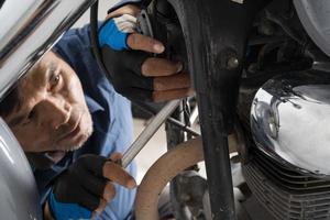 Leute reparieren ein Motorrad, verwenden einen Schraubenschlüssel und einen Schraubendreher, um zu arbeiten foto