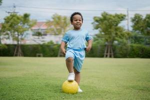 Süßer kleiner Junge mit Fußball im Park an einem sonnigen Tag. foto