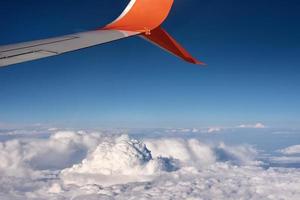 Flugzeugflügel und flauschige Wolke, Blick aus dem Flugzeugfenster foto