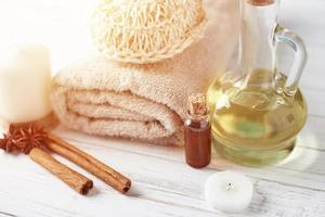 handtücher, kerze und massageöl auf weißem tisch