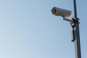 Überwachungskamera auf Hintergrund des blauen Himmels. Post zur Sicherheitsansicht foto