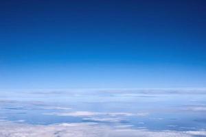 blauer himmel über den wolken aus dem flugzeugfenster foto