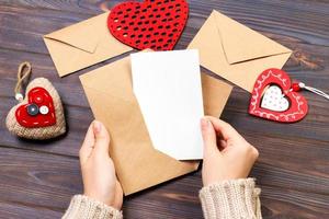 Mädchen, das einen Umschlag mit Valentinsherzen hält. valentinstagkonzept mit copyspace