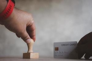 Kreditkarte mit Holzstempel. konzept der kreditkarte jetzt von der bank beantragen. Bank genehmigte neue Kreditkarte. foto