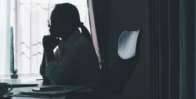 stress geschäftsfrau person von harter arbeit, depression im büro. müde und ängstliche mitarbeiterin mit unzufriedenem problemjob. junge Geschäftsfrau, die traurig vor Laptop-Computer auf Schreibtisch sitzt. foto