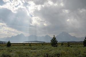 sonnenstrahlen, die von den wolken über der wunderschönen landschaft im yellowstone park ausgehen foto