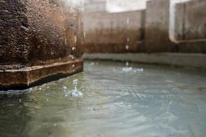 Wassertropfen in einem alten europäischen Trockenbrunnen aus Stein foto