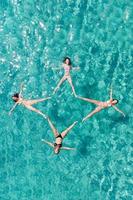 Vier Freundinnen, die sich im Meer entspannen foto