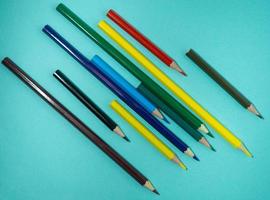 farbige Holzstifte auf farbigem Papier. gespitzte Bleistifte. Zeichenwerkzeug. Zubehör für Kreativität.