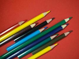 farbige Holzstifte auf farbigem Papier. gespitzte Bleistifte. Zeichenwerkzeug. Zubehör für Kreativität. foto