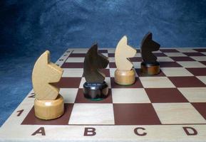 Schachbrett mit Figuren. Schach aus Holz. Brettspiele. Standort der Gegner. Gegenstrategie. Pferde foto