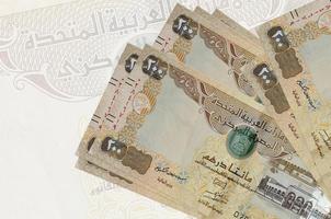 200 VAE-Dirham-Scheine liegen im Stapel auf dem Hintergrund einer großen halbtransparenten Banknote. abstrakte Darstellung der Landeswährung foto