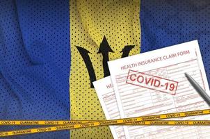 barbados-flagge und krankenversicherungsantragsformular mit covid-19-stempel. Coronavirus- oder 2019-ncov-Viruskonzept foto