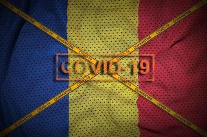 rumänische flagge und covid-19-stempel mit orangefarbenem quarantäne-grenzbandkreuz. Coronavirus- oder 2019-ncov-Viruskonzept foto