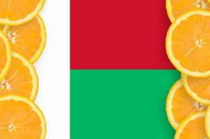 madagaskar-flagge im vertikalen rahmen der zitrusfruchtscheiben foto