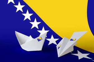 bosnien und herzegowina flagge auf papier origami flugzeug und boot dargestellt. handgemachtes kunstkonzept foto