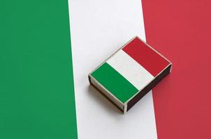 Die italienische Flagge ist auf einer Streichholzschachtel abgebildet, die auf einer großen Flagge liegt foto