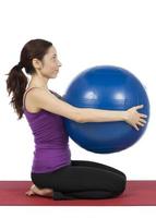 Fitnessfrau mit einem Pilatesball, vertikal