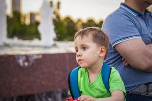 Porträt eines Kindes, eines Jungen vor dem Hintergrund urbaner Landschaften von Wolkenkratzern und Hochhäusern im Freien. Kinder, reisen. Lebensstil in der Stadt. Zentrum, Straßen. foto