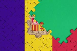 Die Andorra-Flagge ist auf einem fertigen Puzzle mit freiem Platz für grüne Kopien auf der rechten Seite abgebildet foto