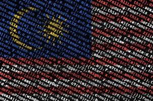 die malaysia-flagge wird auf dem bildschirm mit dem programmcode dargestellt. das konzept der modernen technologie und standortentwicklung foto