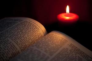 offene Bibel im Licht der roten Kerze - Pfingsten foto