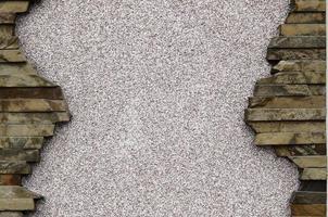 verputzte Betonwand mit einem Rahmen aus flachen Steinen foto