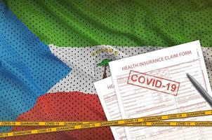 äquatorialguinea-flagge und antragsformular für die krankenversicherung mit covid-19-stempel. Coronavirus- oder 2019-ncov-Viruskonzept foto