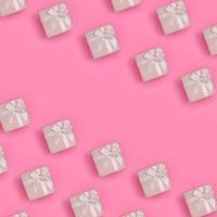 viele rosa geschenkboxen liegen auf texturhintergrund von modepastellrosa farbpapier in minimalem konzept. abstraktes trendiges Muster foto